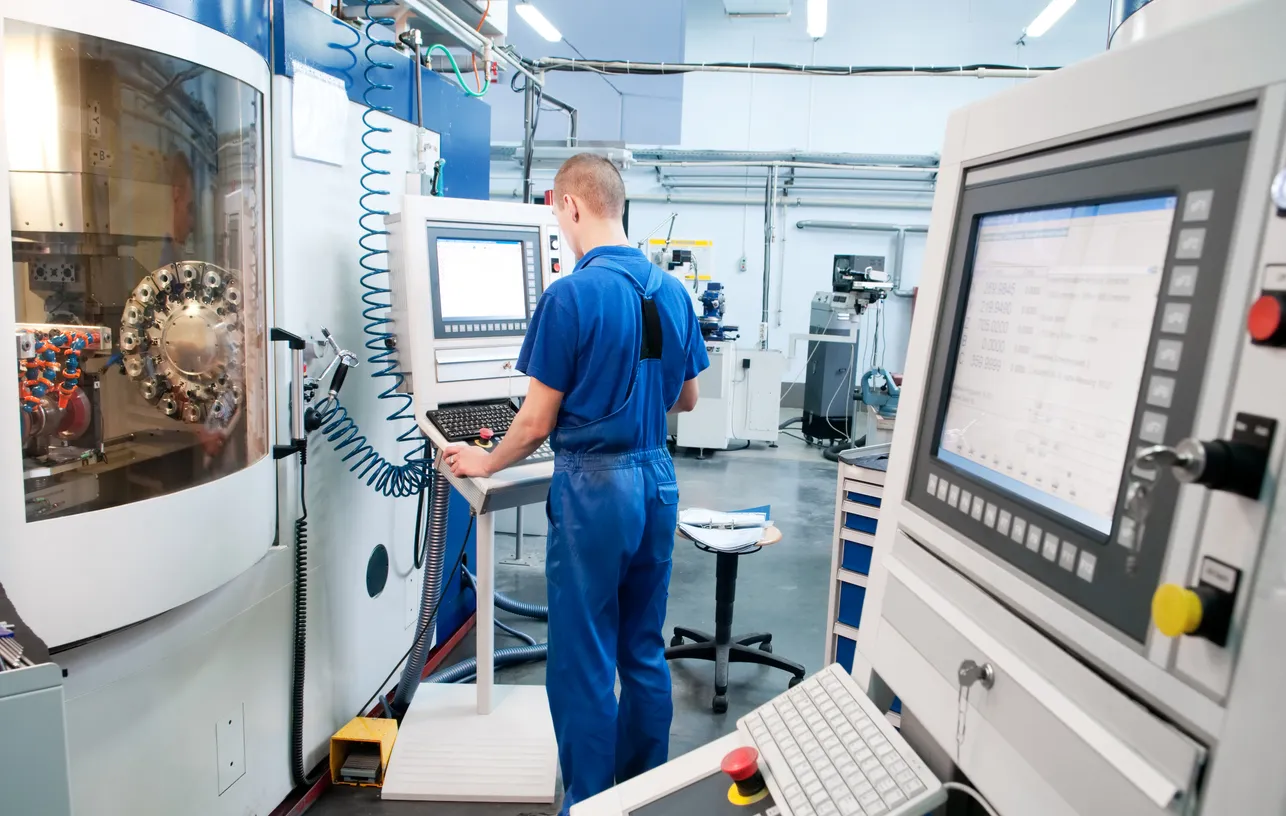 Trabajador operando un centro de máquinas CNC