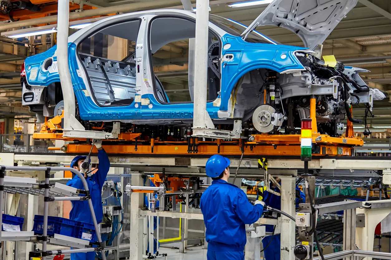Los trabajadores están armando del chasis del coche en la línea