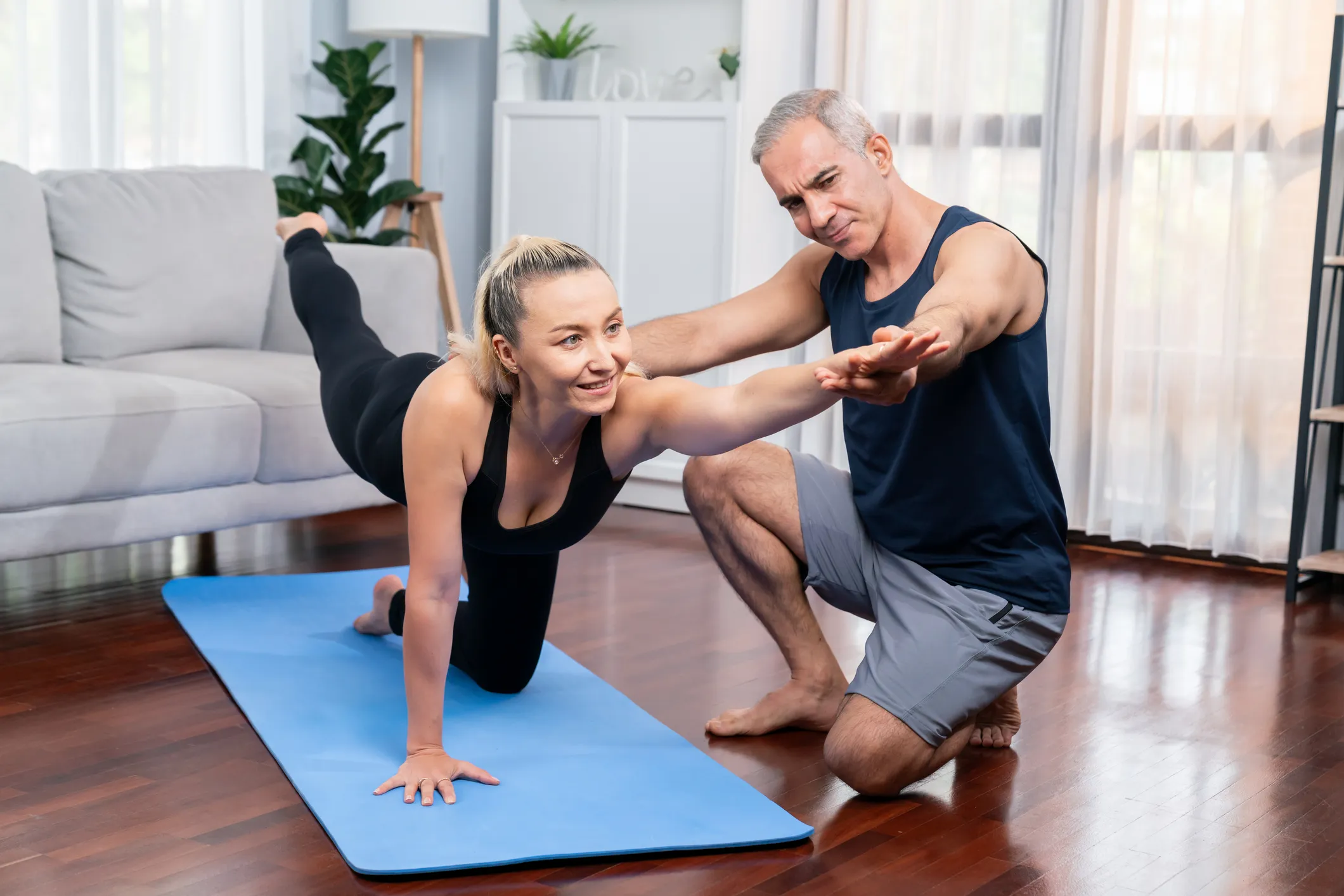 Entrenandor personal con mujer adulta entrenando en casa