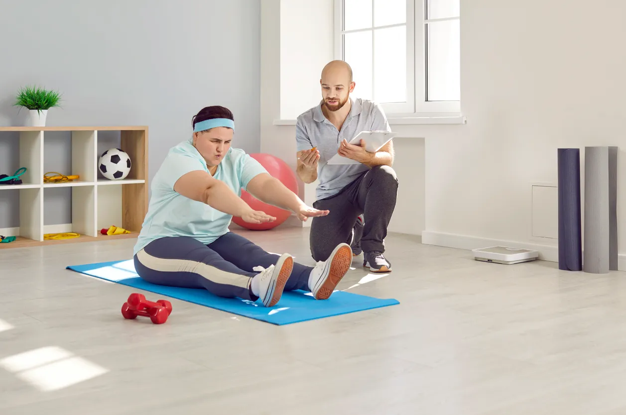 Entrenador personal  con mujer en casa realizando ejercicio