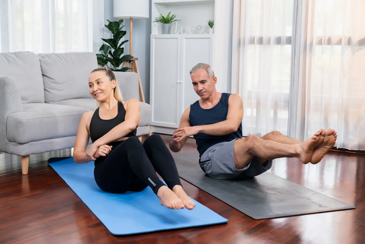 entrenador con mujer en entrenamiento funcional en casa