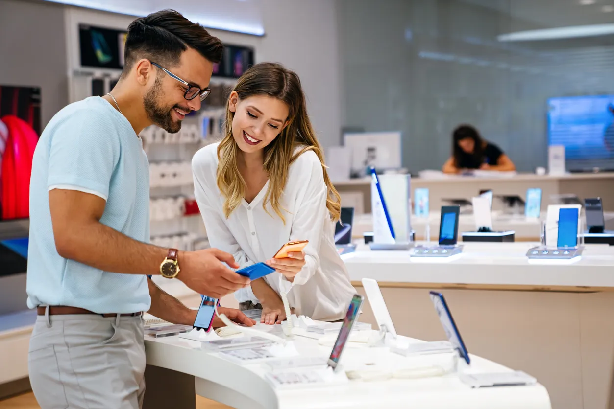 Joven pareja comprando un celular con un distribuidor de celulares