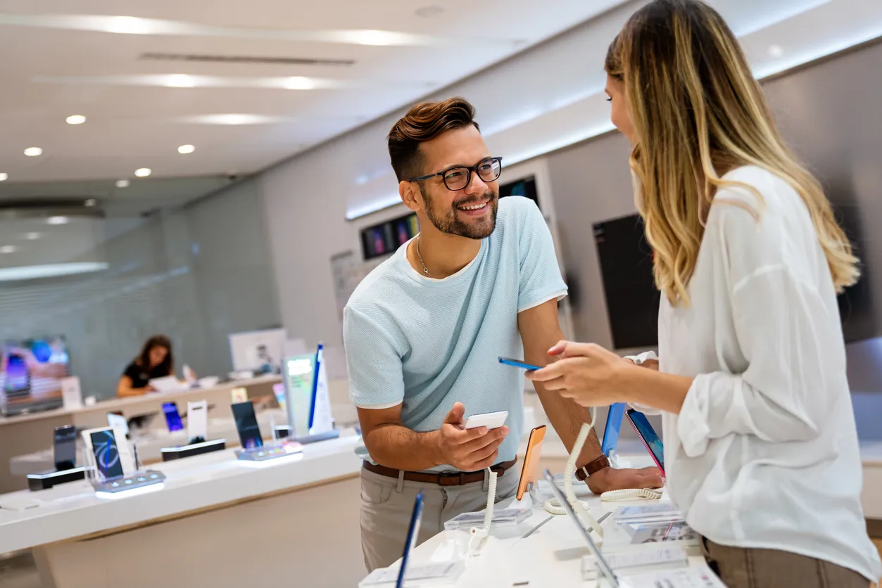 Dos jovenes están eligiendo su celular en un tienda que es distribuidor autorizado Samsung