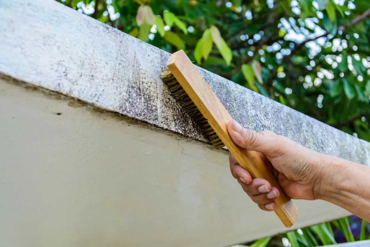 Mano cepillando el concreto de una construcción
