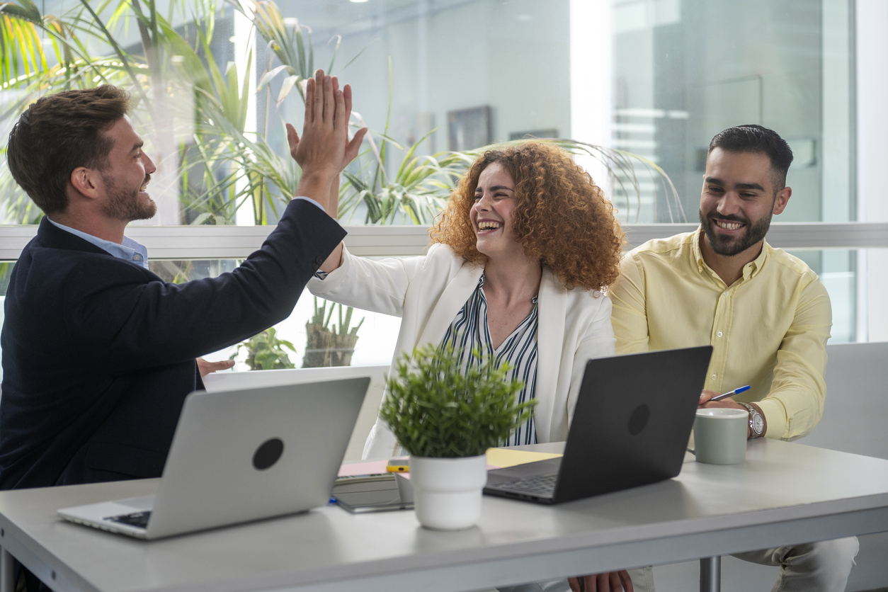 Business team celebrating success with high five in office stock photo