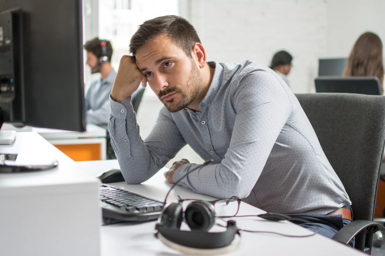 Hombre de barba preocupado mirando la pantalla del ordenador en la oficina