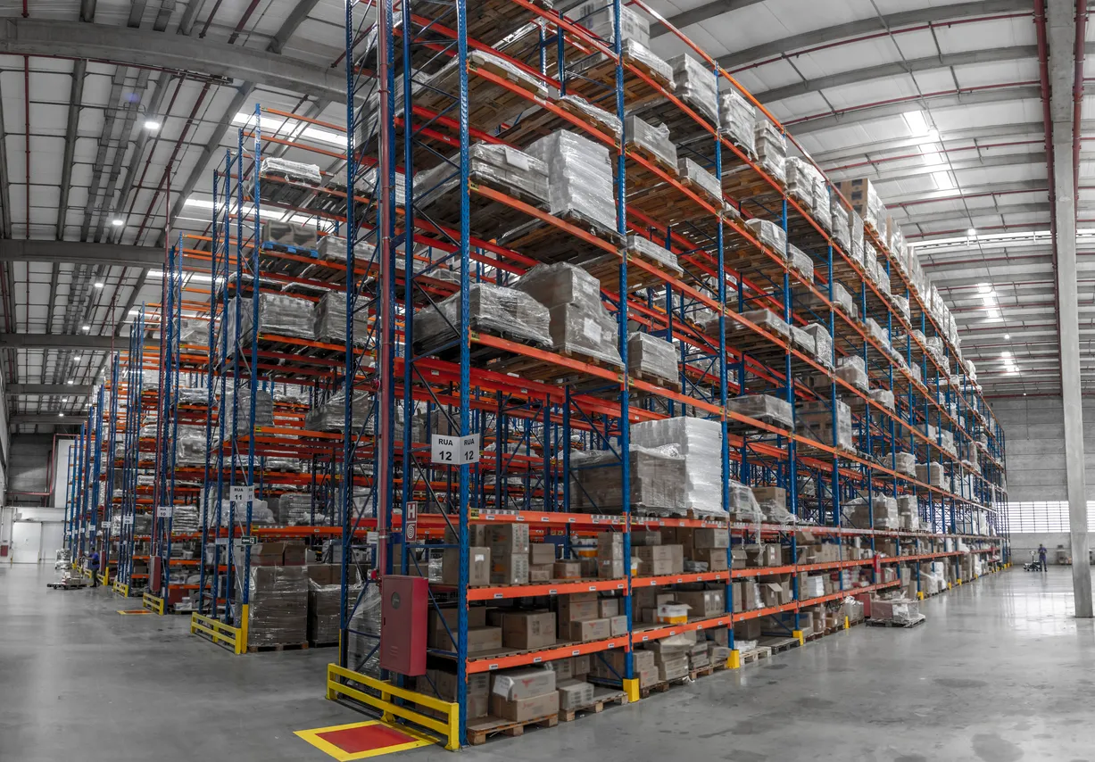 Trabajadores y montacargas en funcionamiento en el almacén logístico y las cajas de distribución.