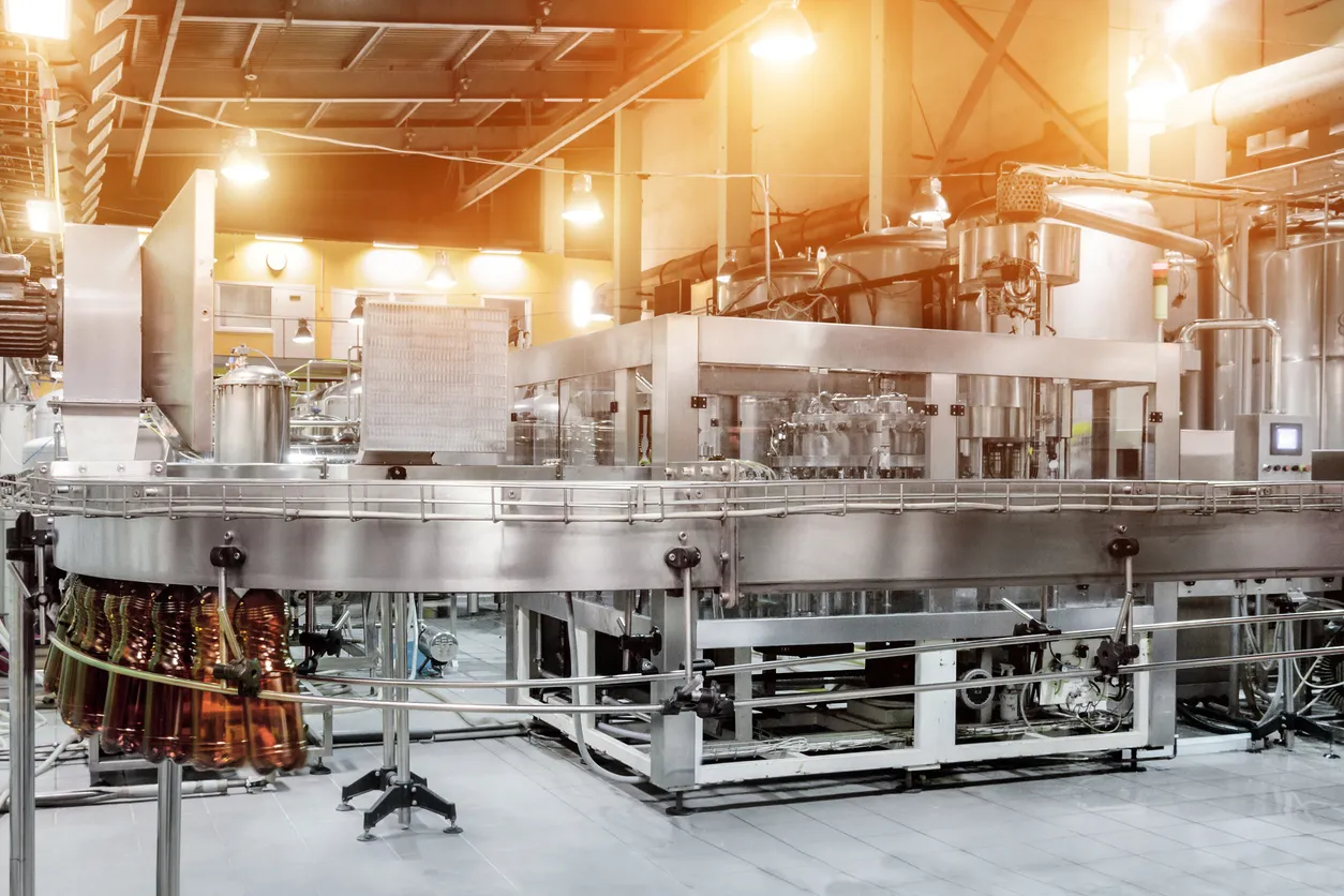 Sistema de cinta transportadora vacío dentro de una moderna fábrica industrial. La máquina de llenado de botellas