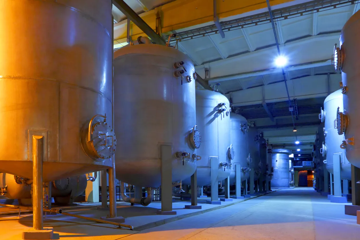 Interior de una enorme fábrica química con tanques gigantes.