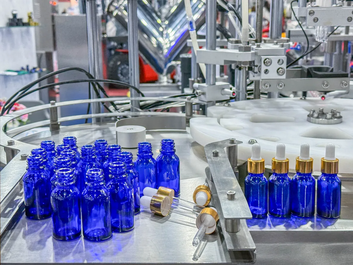 Botellas de vidrio en una cinta transportadora en una máquina de llenado vertical automática