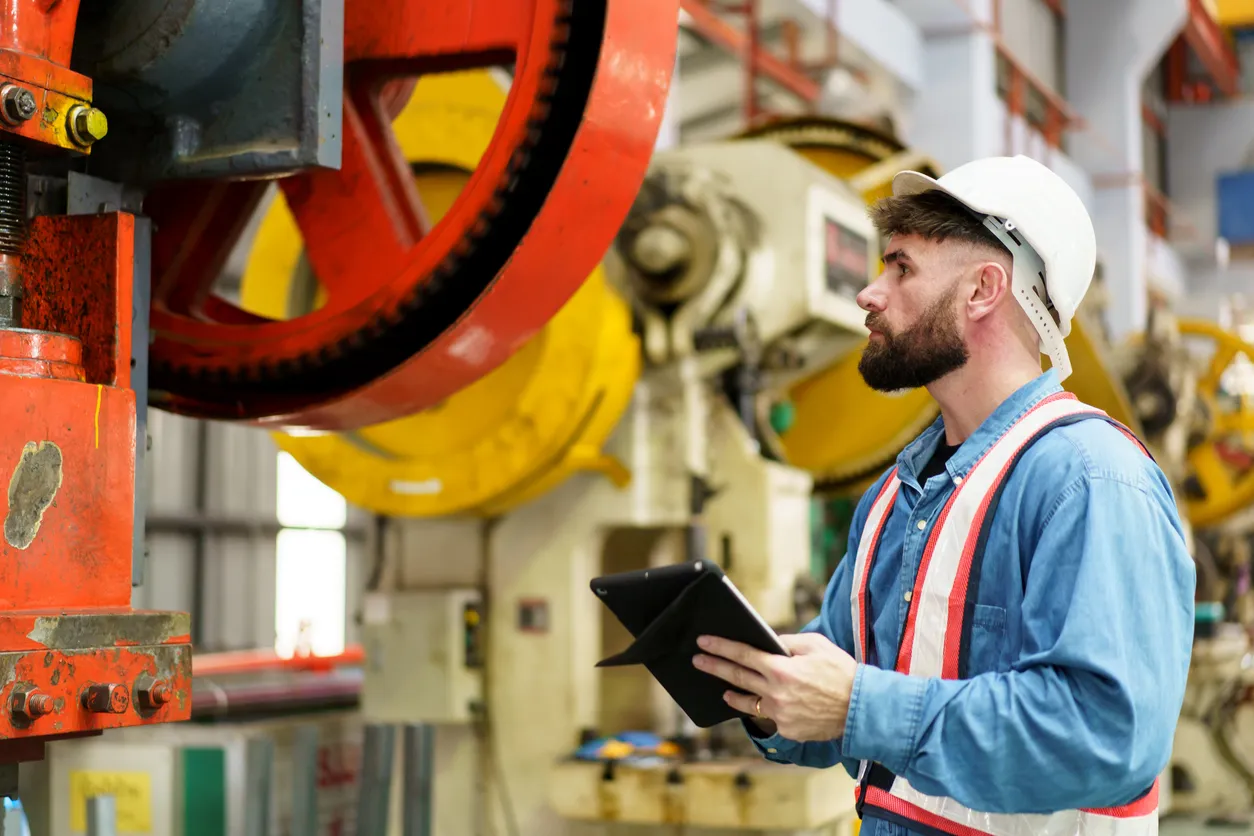 Técnico trabajando en fábrica con varias maquinas de metalmecánica