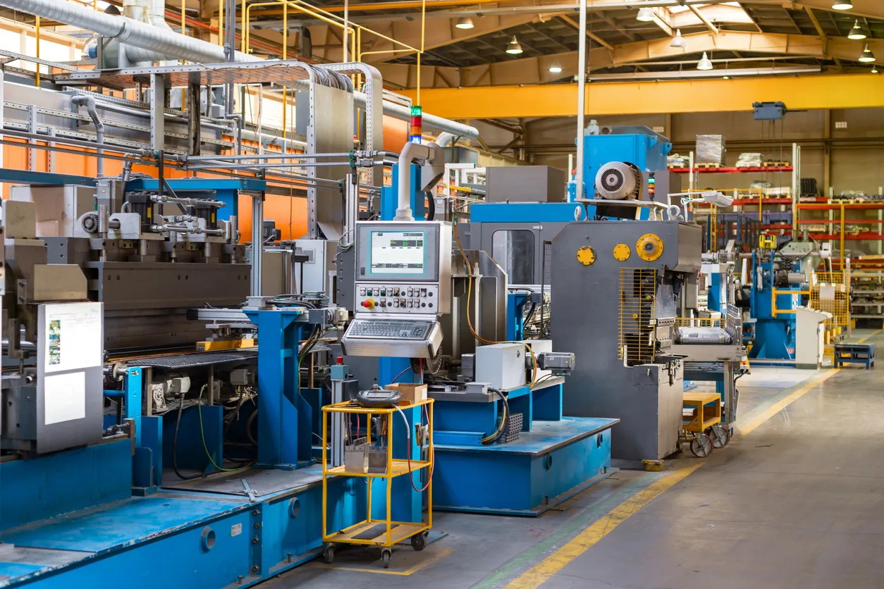 el interior de una fábrica con maquinas que requieren mantenimiento y limpieza cuidando la pintura de las partes metálicas