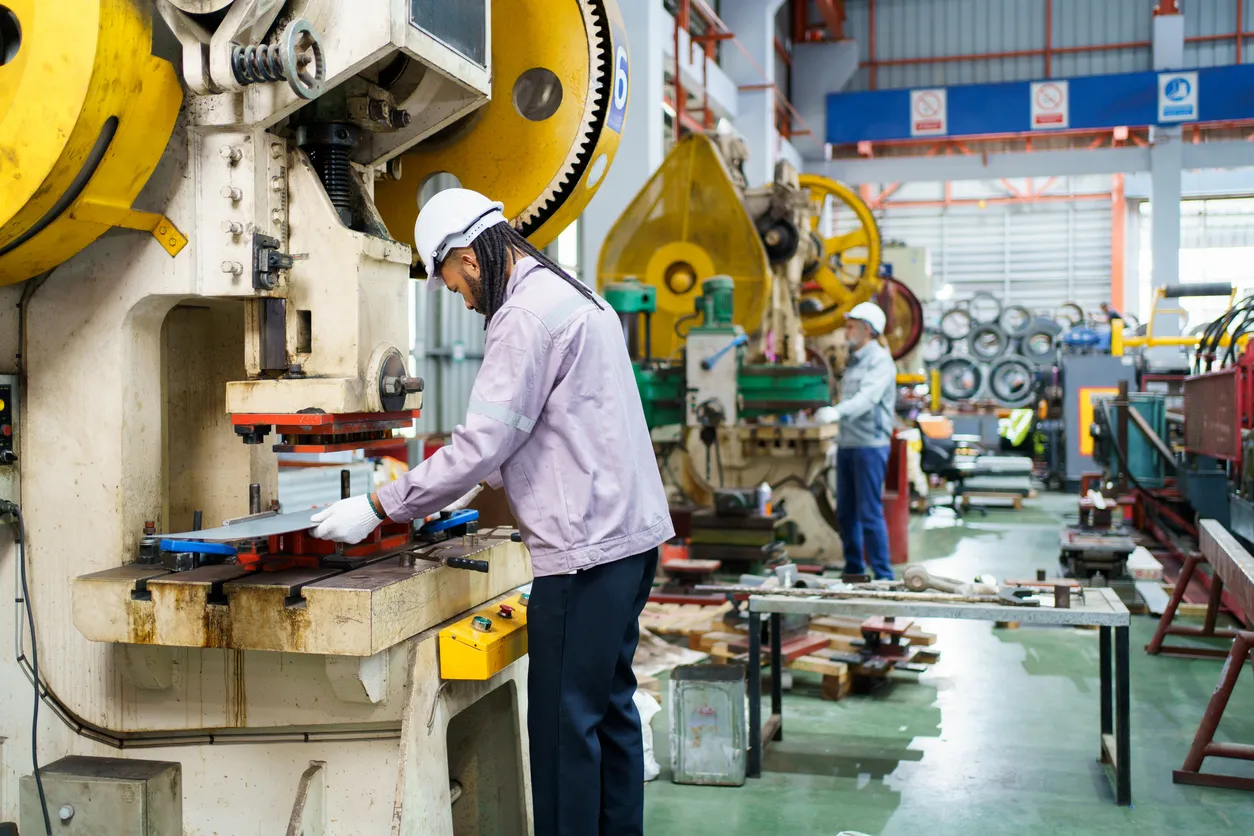 Ingeniero que opera la máquina cortadora de chapa metálica en la fábrica