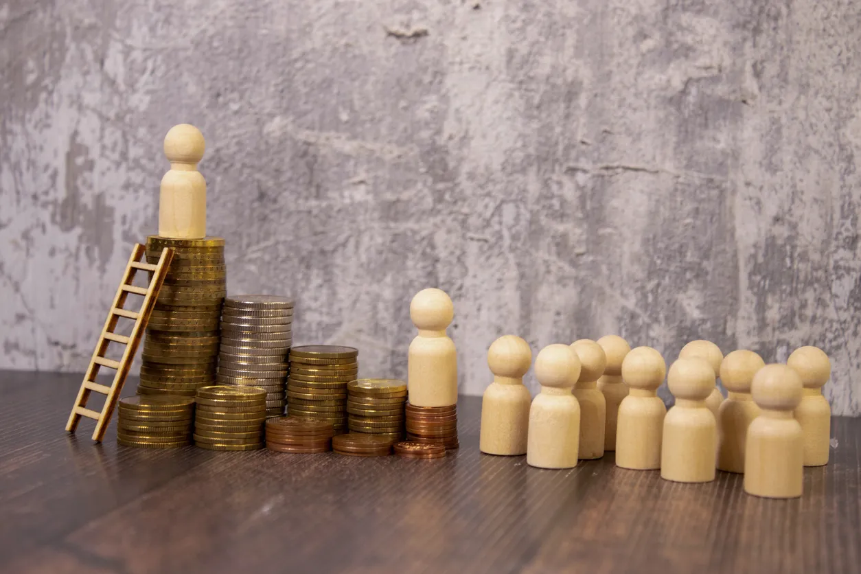 gráfico que muestra una figura con una gran cantidad de monedas y debajo muhcas figuras simulando la desigualdad salarial