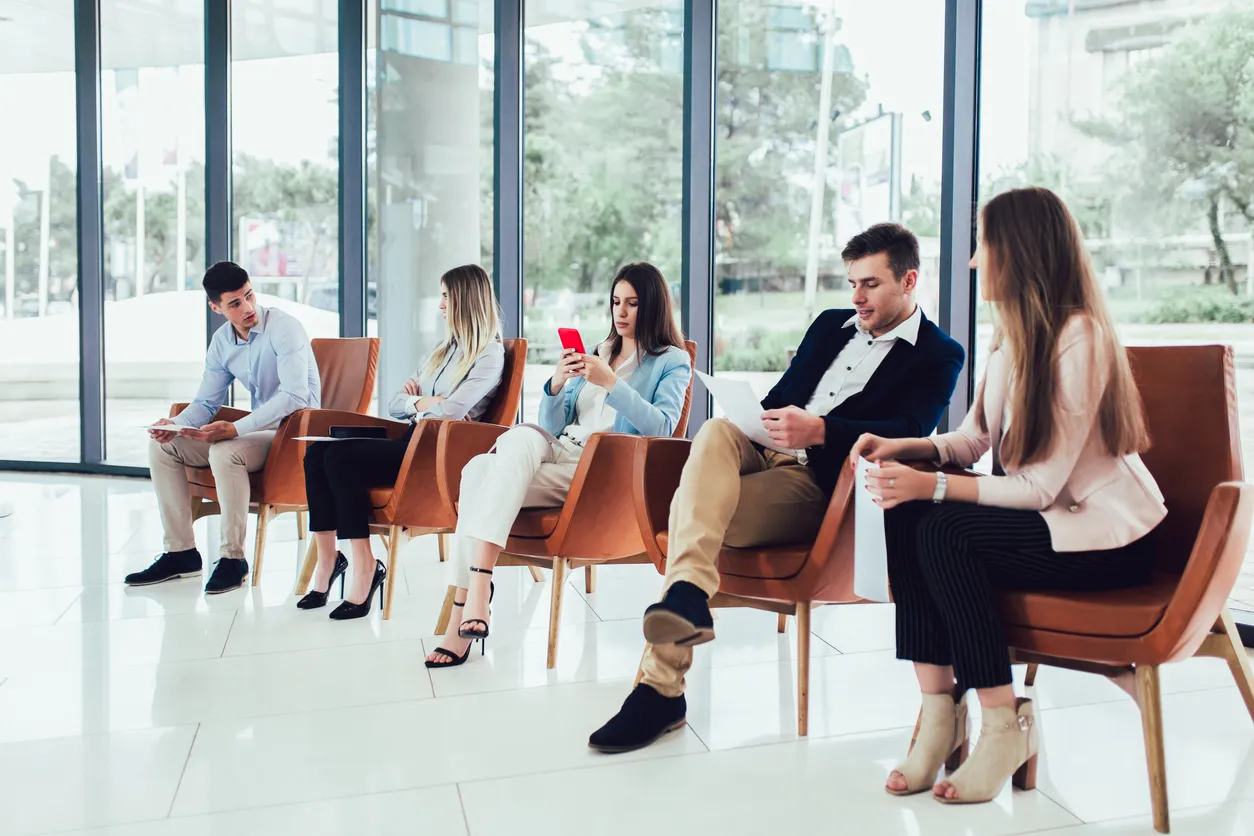 grupo de personas esperando para ser entrevestidas para un empleo en una oficina moderna