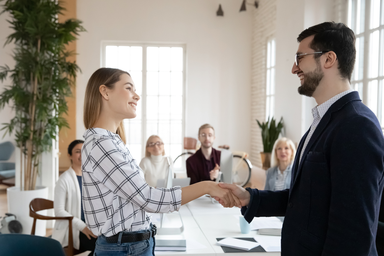 Smiling businessman handshake excited Caucasian employee greet with promotion
