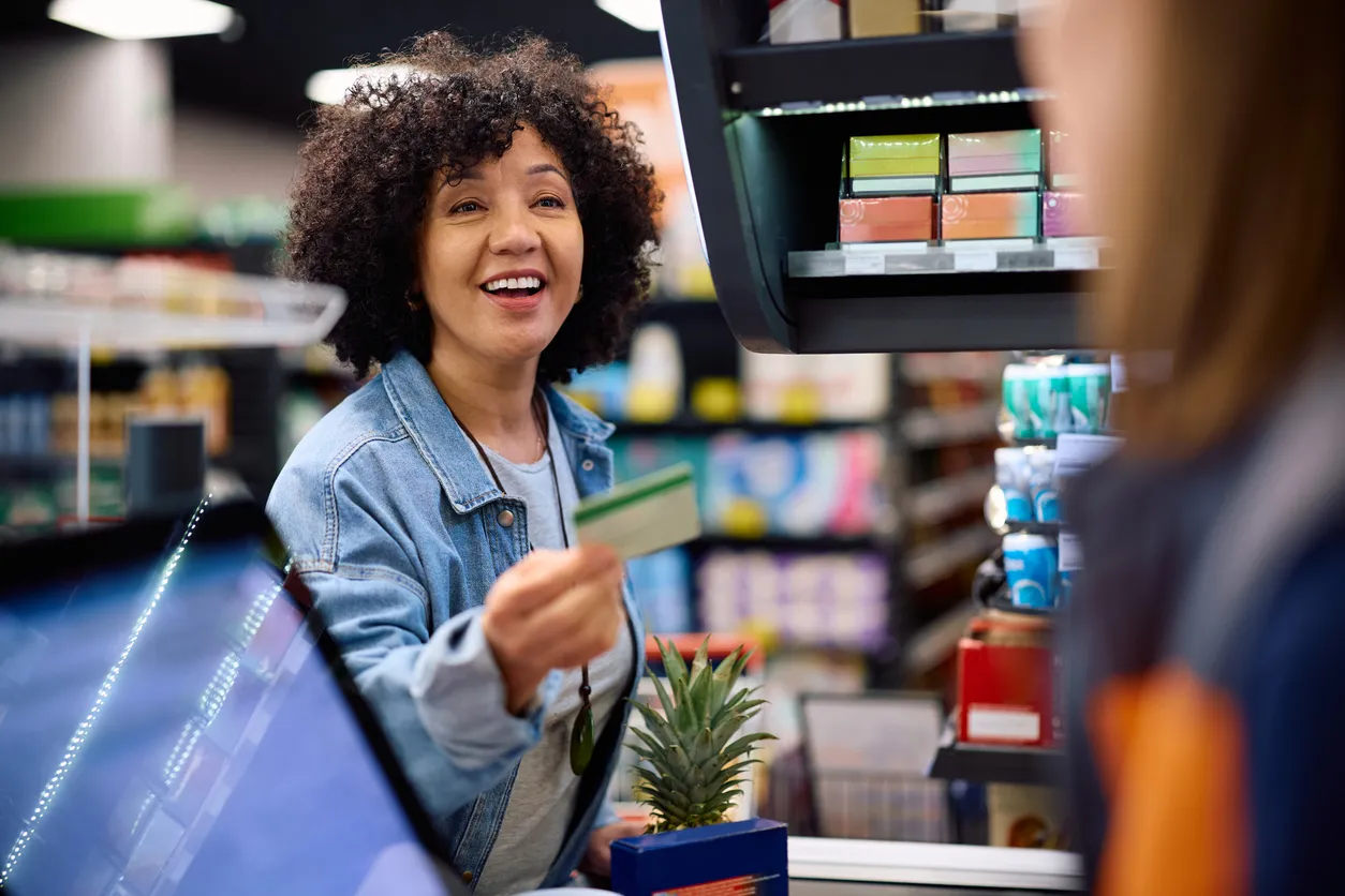 mujer madura realizando compras con su tarjeta de vales de despensa 