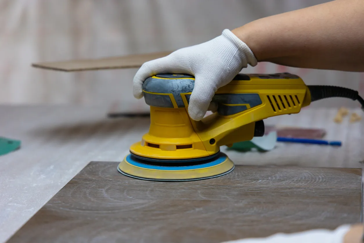 trabajador usando lijadora orbital en madera