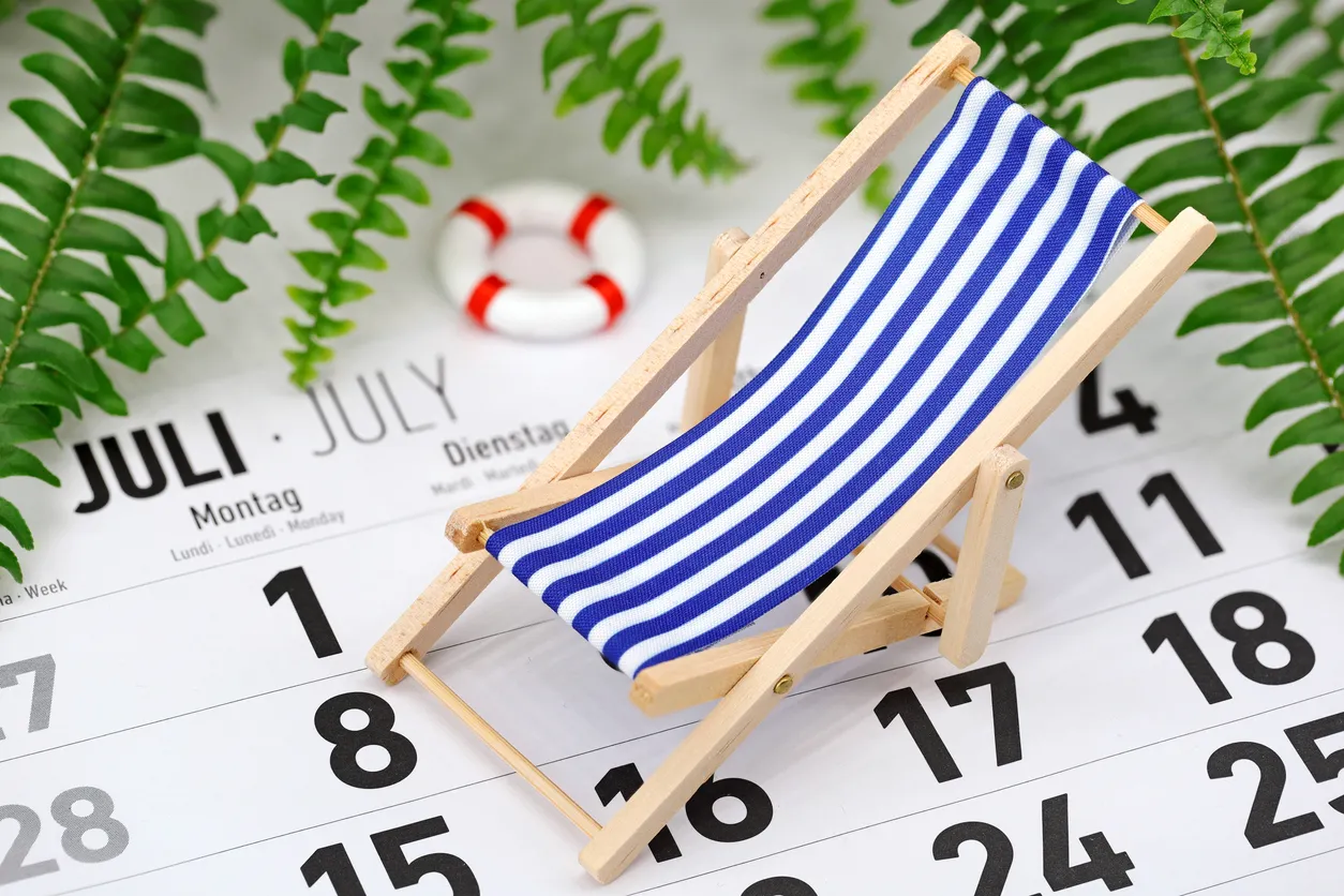 El calendario mensual alemán muestra el mes de julio con tumbona y plantas tropicales en el fondo
