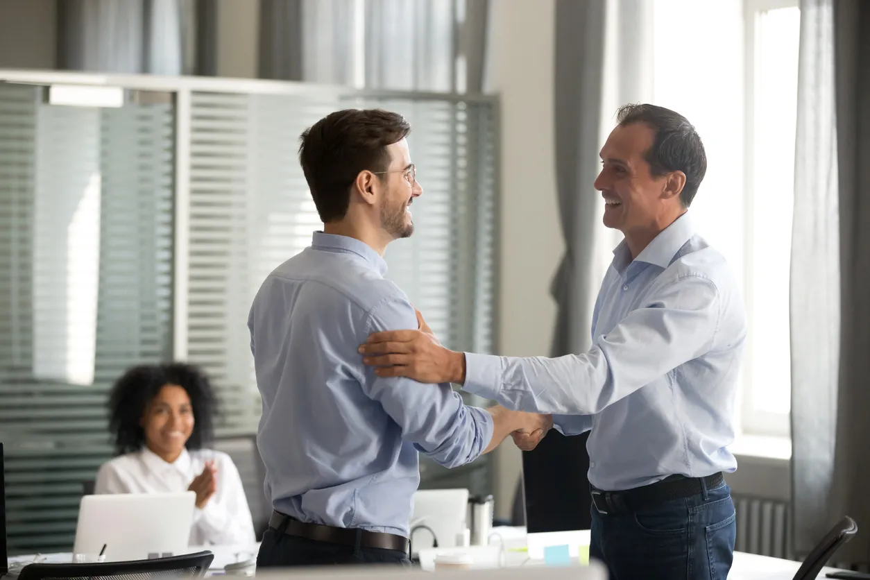 Sonrisa respeto de mediana edad apretón de manos de ceo exitoso trabajador masculino mostrando