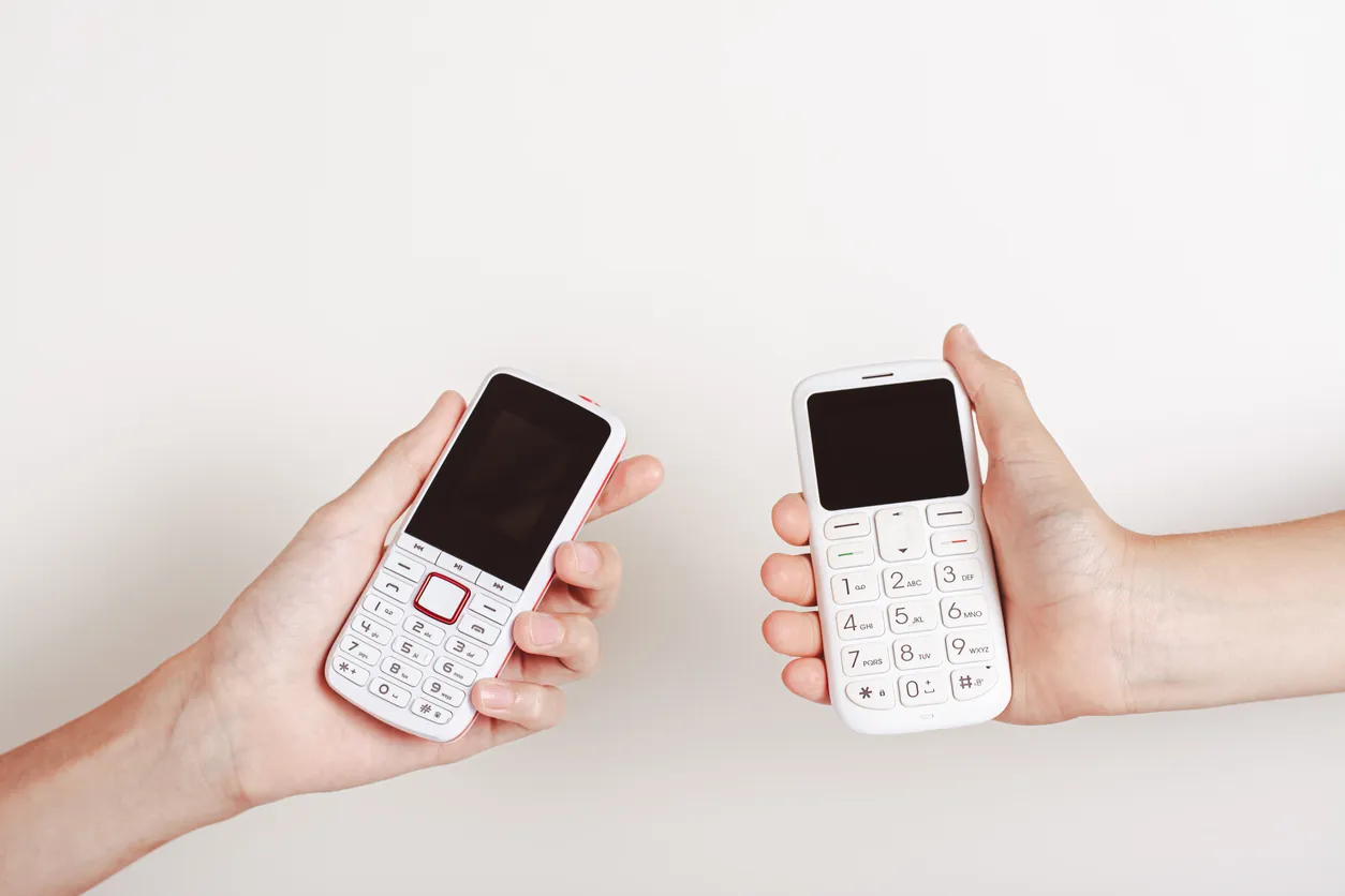 Dos manos sostienen dos celulares cacahuate