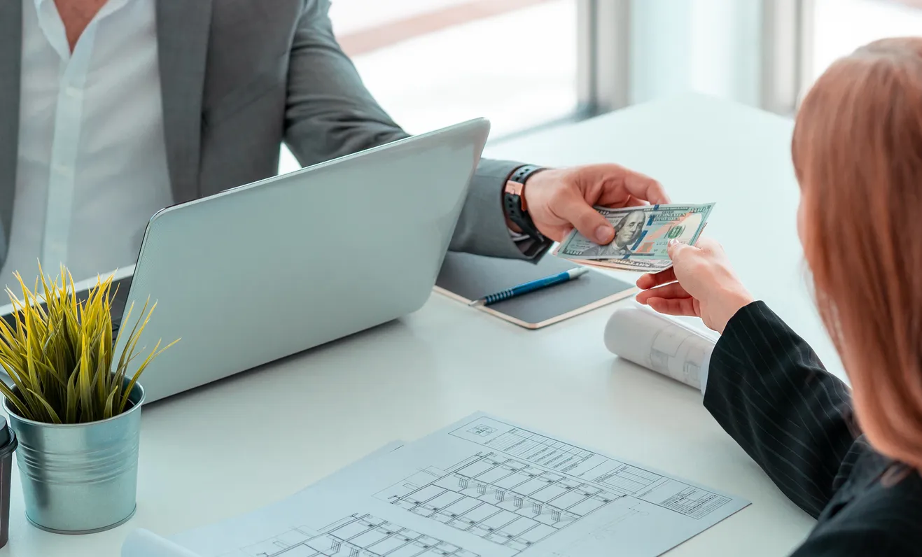 Trabajadora recibiendo dinero en una oficina, representantdo lo que es un adelanto de nómina