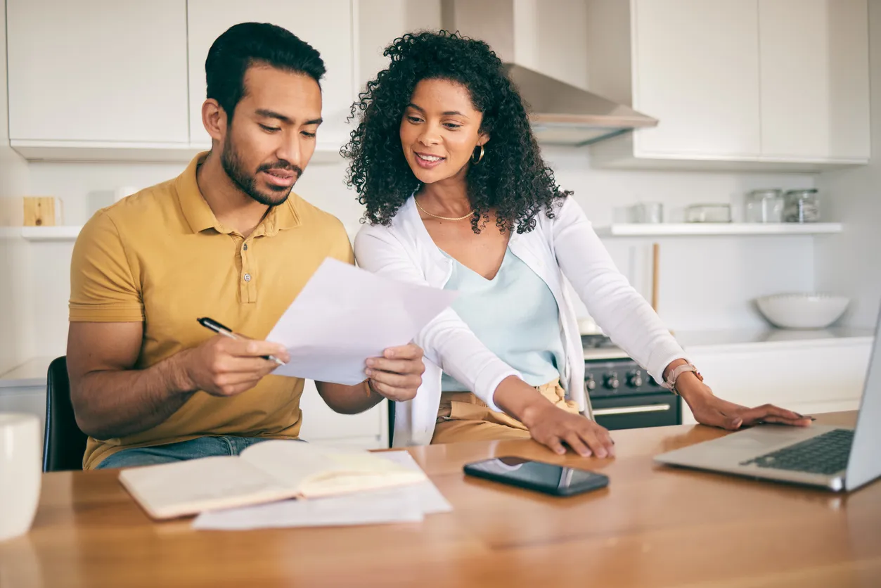 Pareja, papeleo de seguros y planificación presupuestaria con computadora portátil, facturas y finanzas con impuestos e hipot