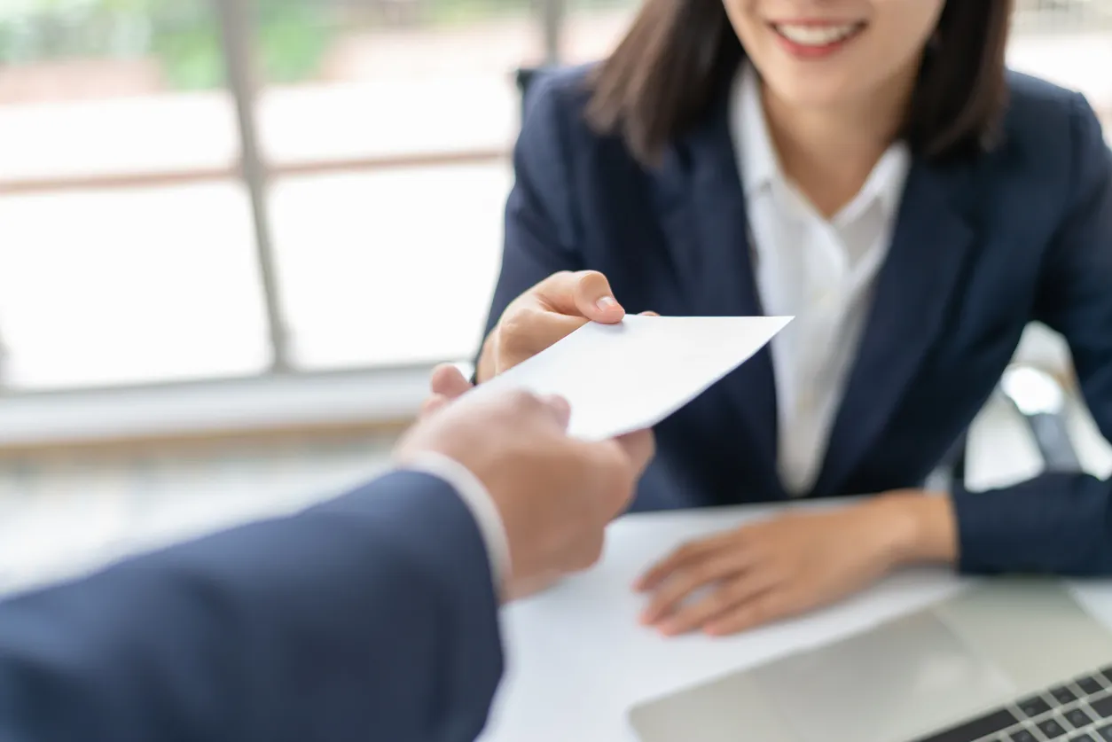 Mujer de negocios asiática joven recibe dinero de bono o sueldo de jefe o Gerente de oficina feliz.