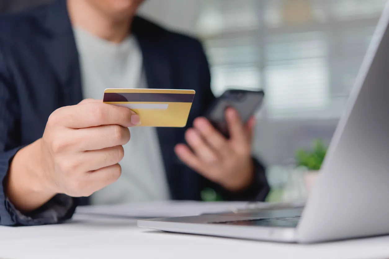 El cliente verifica la compra en línea con tarjeta de crédito y teléfono inteligente en el escritorio de la oficina cerca de 
