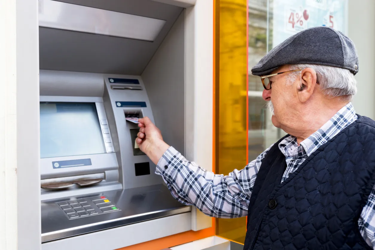 persona mayor realizando una disposición en cajero automático
