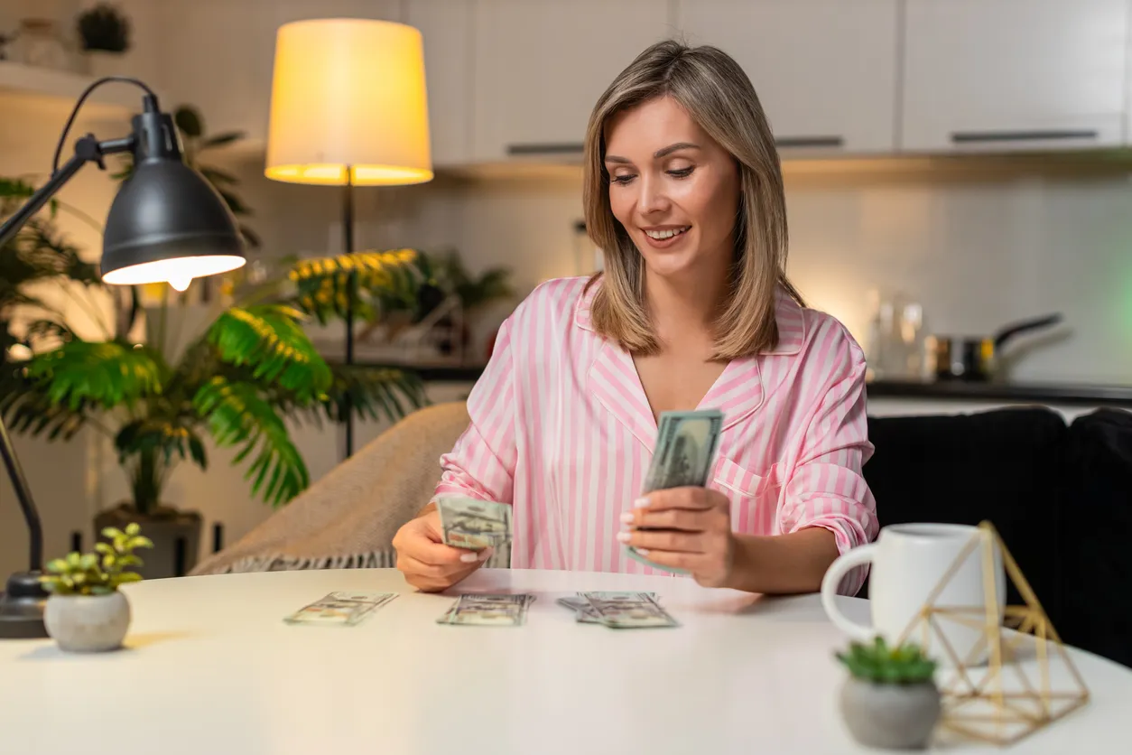 Mujer madura colocando el dinero en diferentes partes sobre la mesa para diversos propositos 