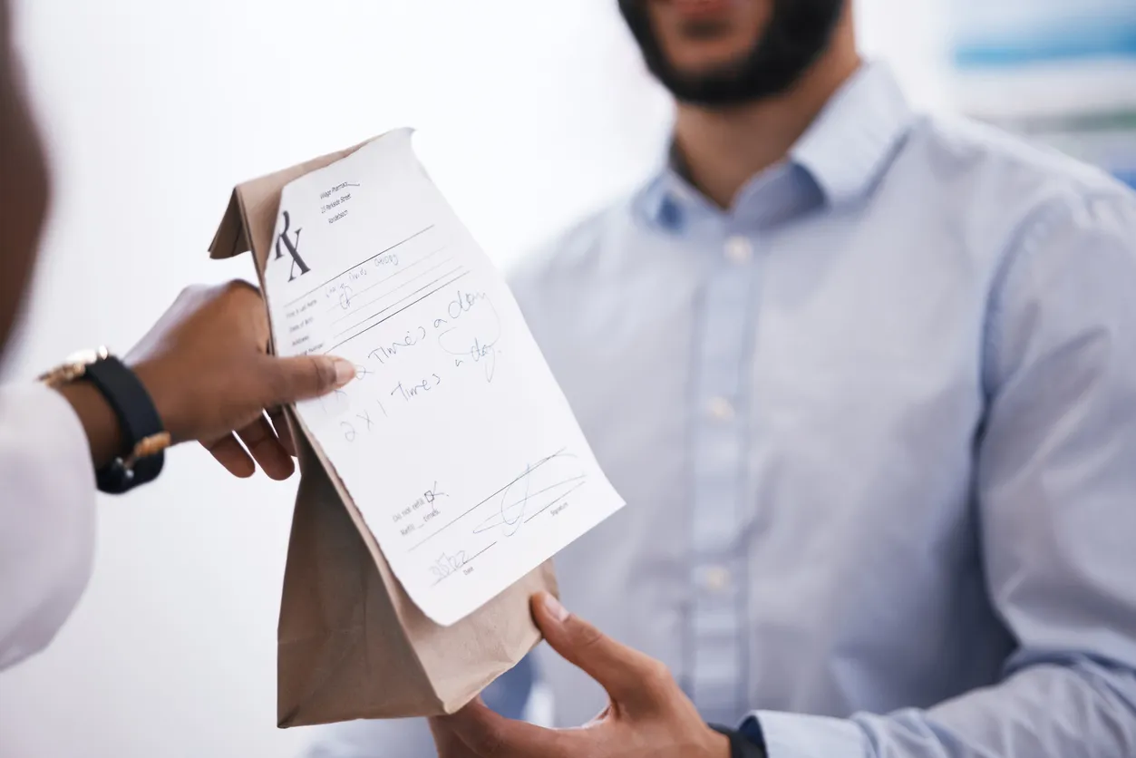 El cliente, medicamento o farmacéutico entrega una bolsa en la farmacia con el recibo de la receta médica.