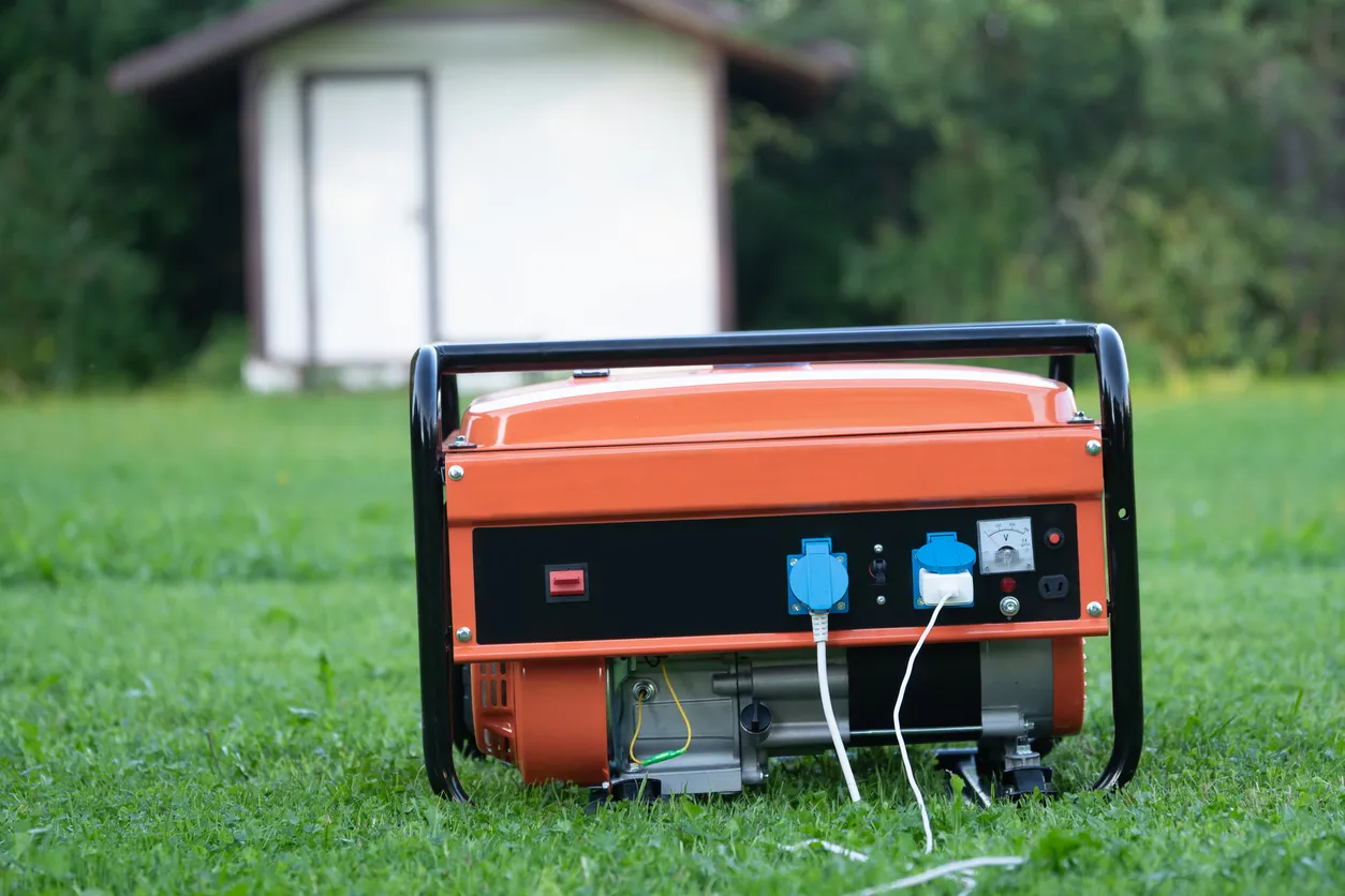 Generador eléctrico portátil en el patio trasero de una casa de verano al aire libre