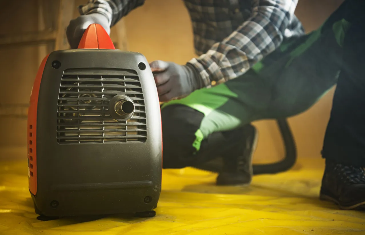 Trabajador de la construcción prepara generador de electricidad de gasolina para trabajar