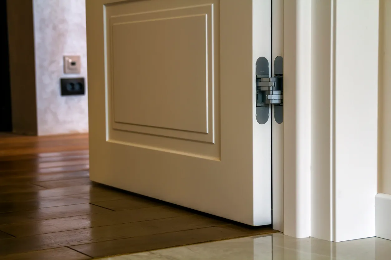 Detalle interior de casa moderna con puerta de blanco y piso de parquet de madera. Apartamento después de primer plano de la 