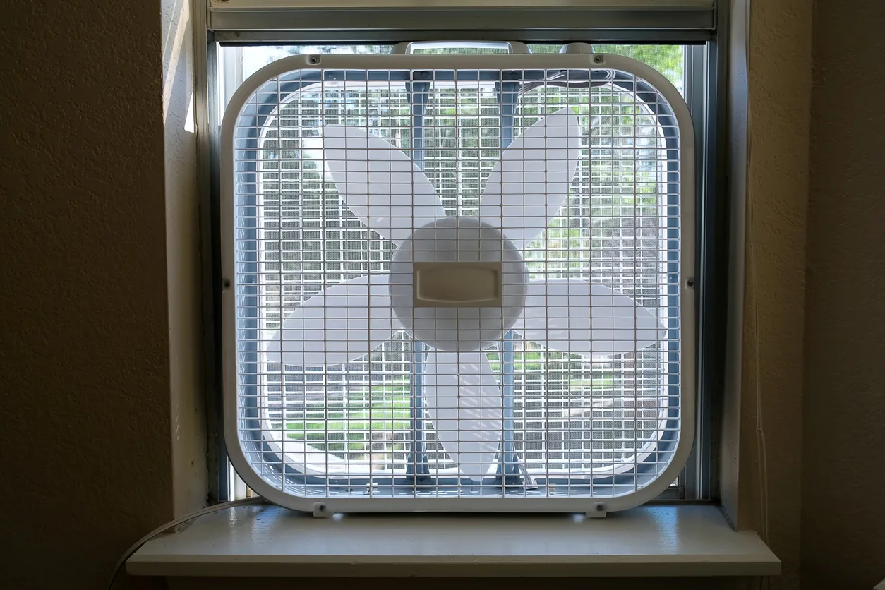 Ventilador clásico de la caja de la ventana insertado en la ventana de la habitación interior