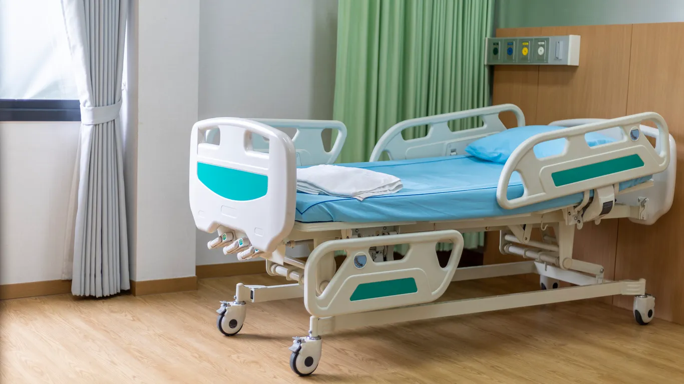 Cama con sábana azul desechable en hospital moderno