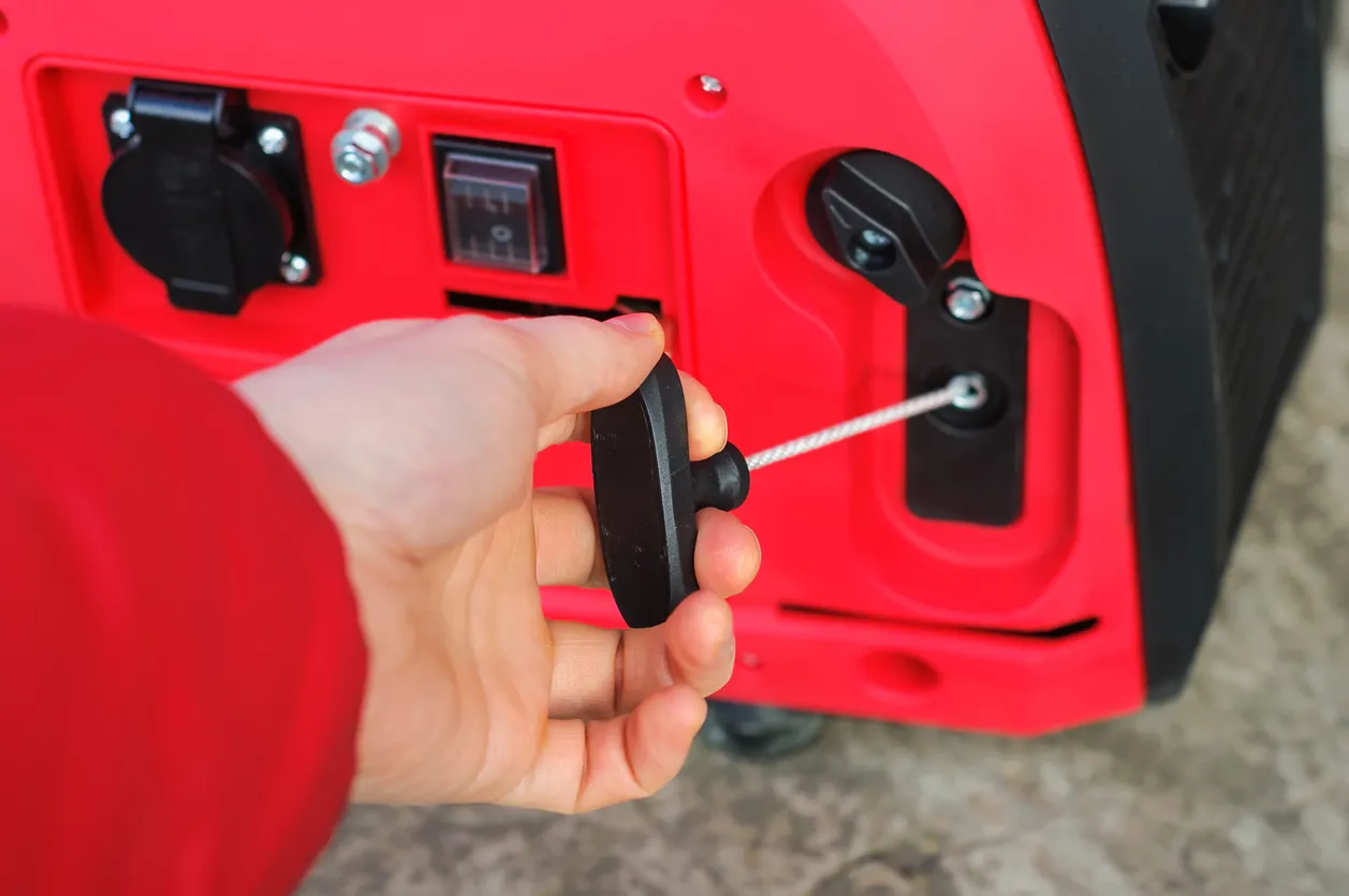 Enciendo el generador inversor de gasolina a mano, el cuerpo rojo tiene Honda escrito en él.