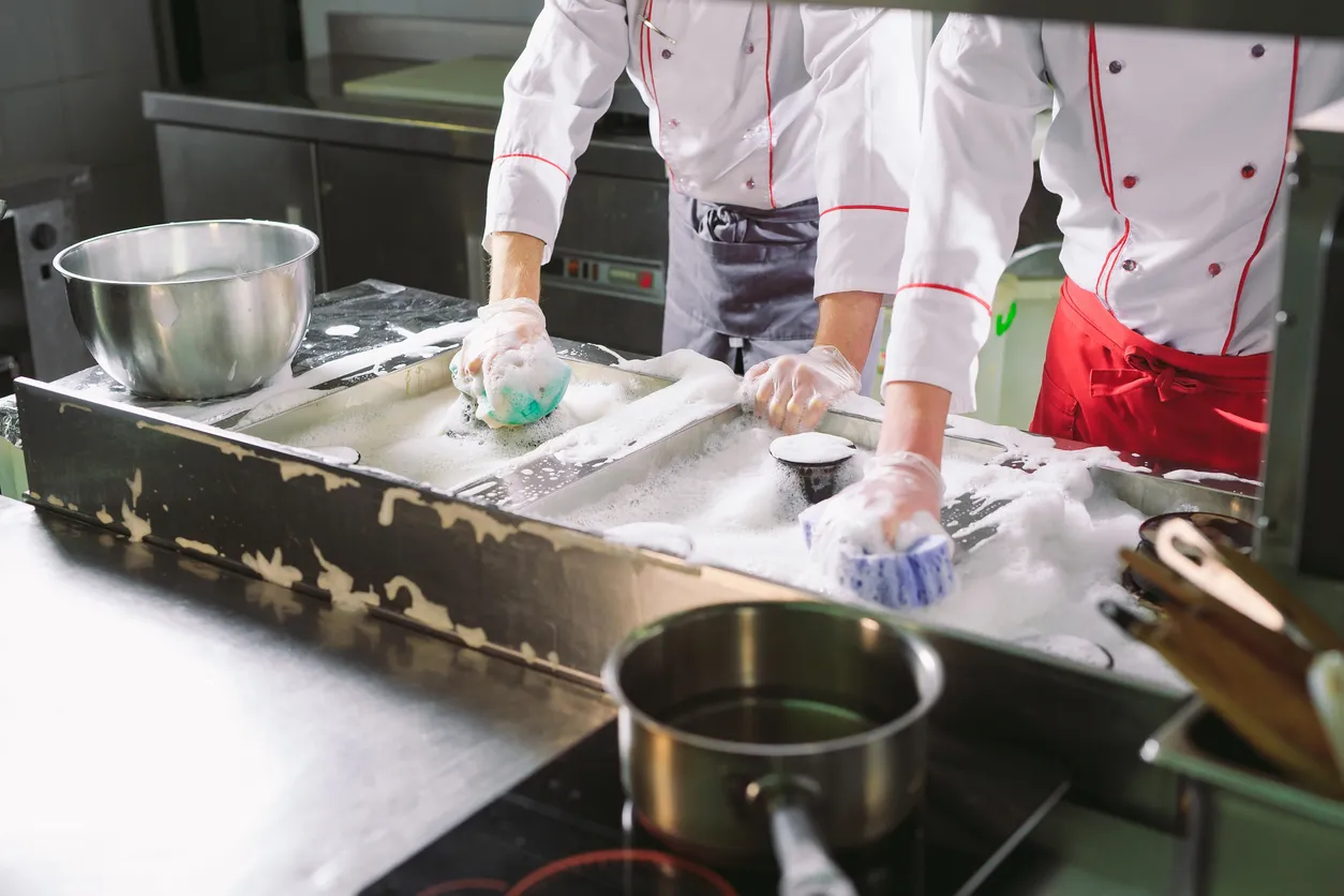 Día sanitario en el restaurante. Las repeticiones lavan el lugar de trabajo. Los cocineros lavan el horno, la estufa