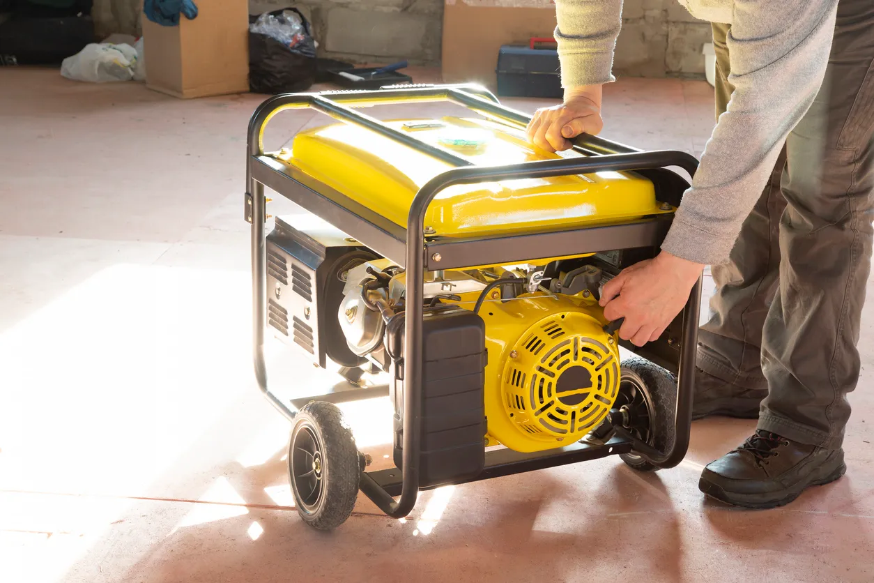 Generador portatil de gasolina en color amarillo siendo operada por una persona