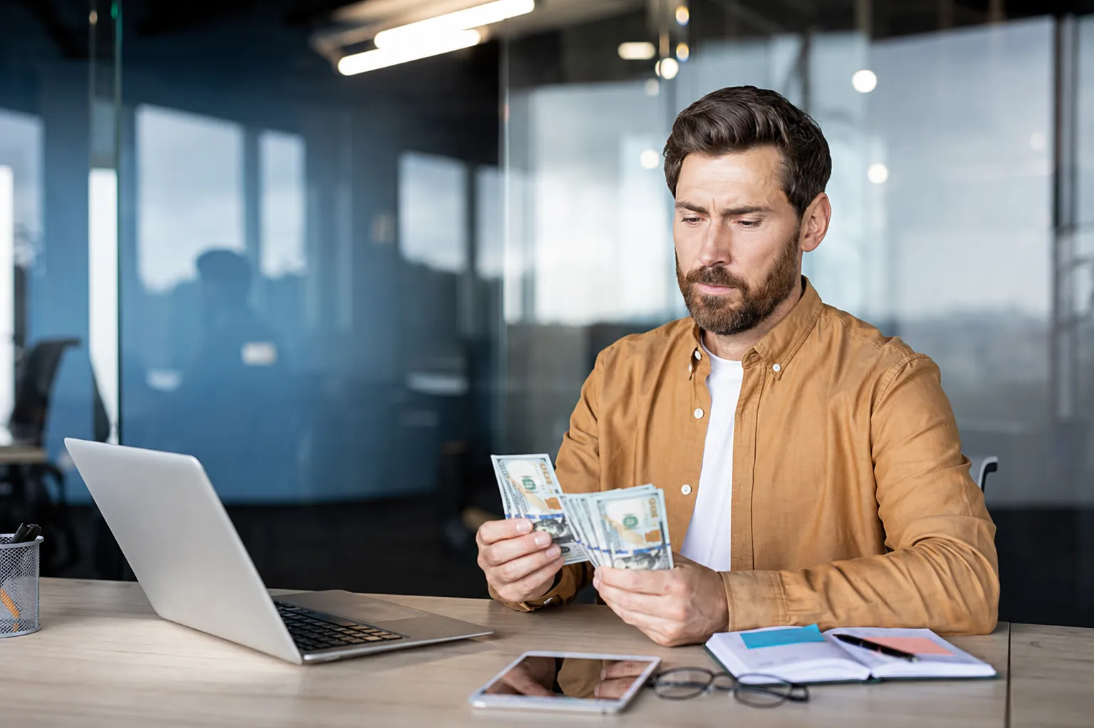Oficina moderna con hombre contando dinero