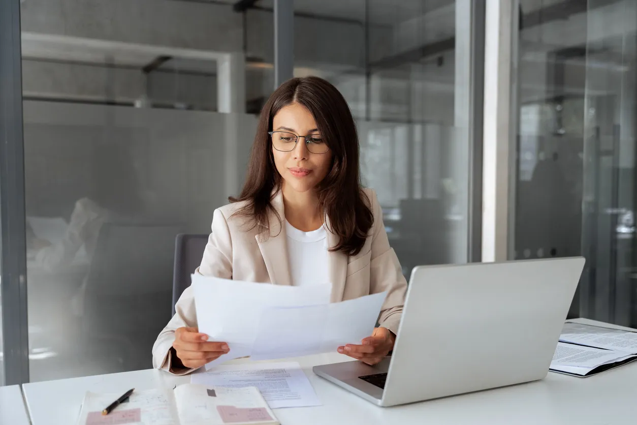 Vendedora de negocios latina concentrada que trabaja en una computadora portátil
