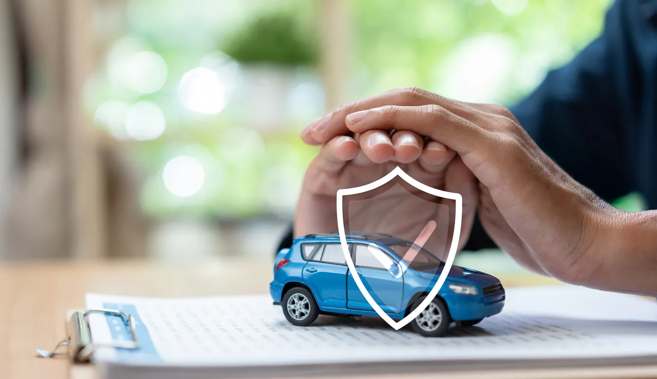 Concepto de protección de seguro de coche con el modelo del vehículo bajo