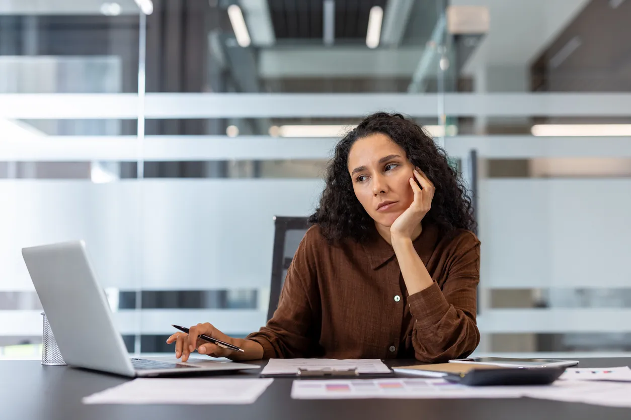 Mujer de negocios que parece aburrida y cansada en el escritorio de la oficina