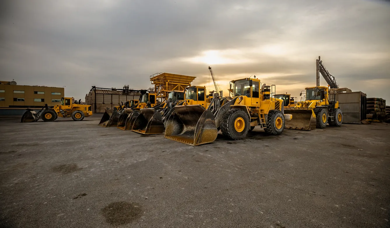 Pala cargadora de ruedas amarilla o bulldozer en formación. Movimiento de tierras y áridos. Obras de construcción. 