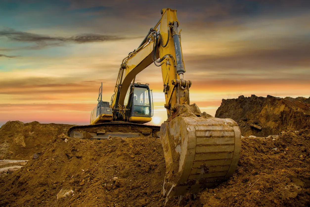 Excavadora de tipo oruga durante el movimiento de tierras en el sitio de construcción.