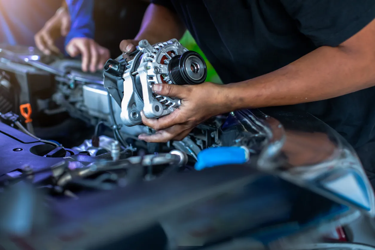 El mecánico está reparando y reemplazando un cargador de batería 