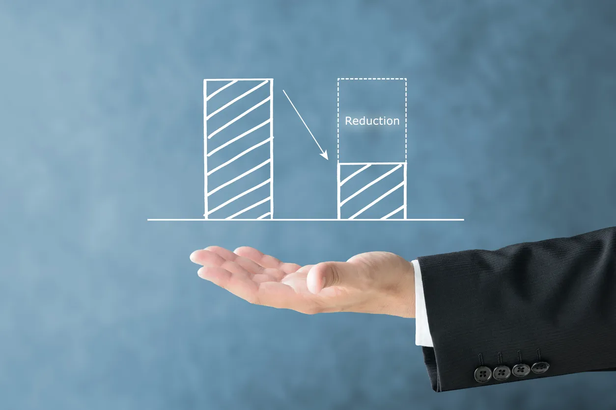 Gráfico y mano de empresario que muestra imagen de reducción de costos y reducción de desperdicios
