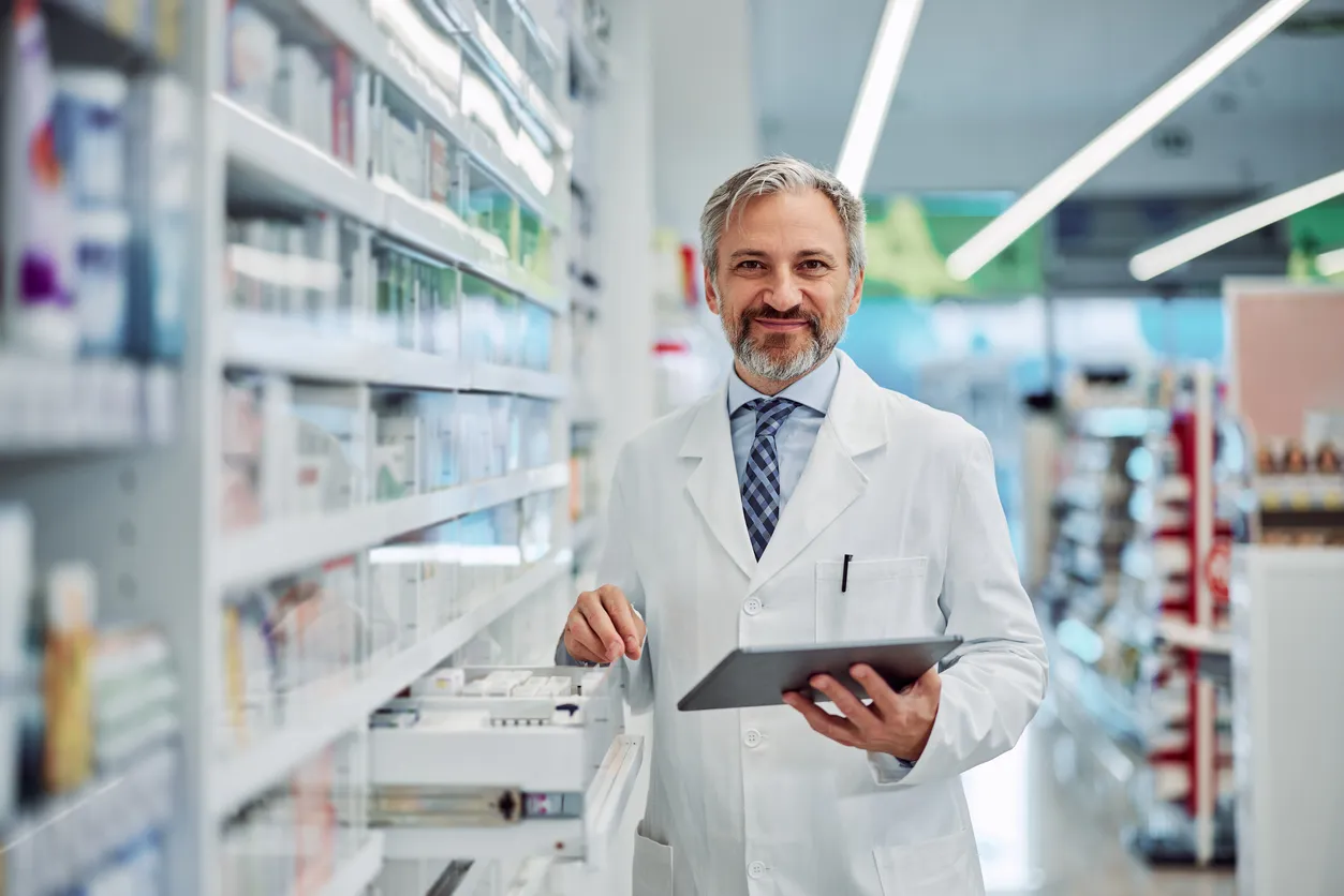 Retrato de un farmacéutico ambicioso con una tableta digital en el trabajo.