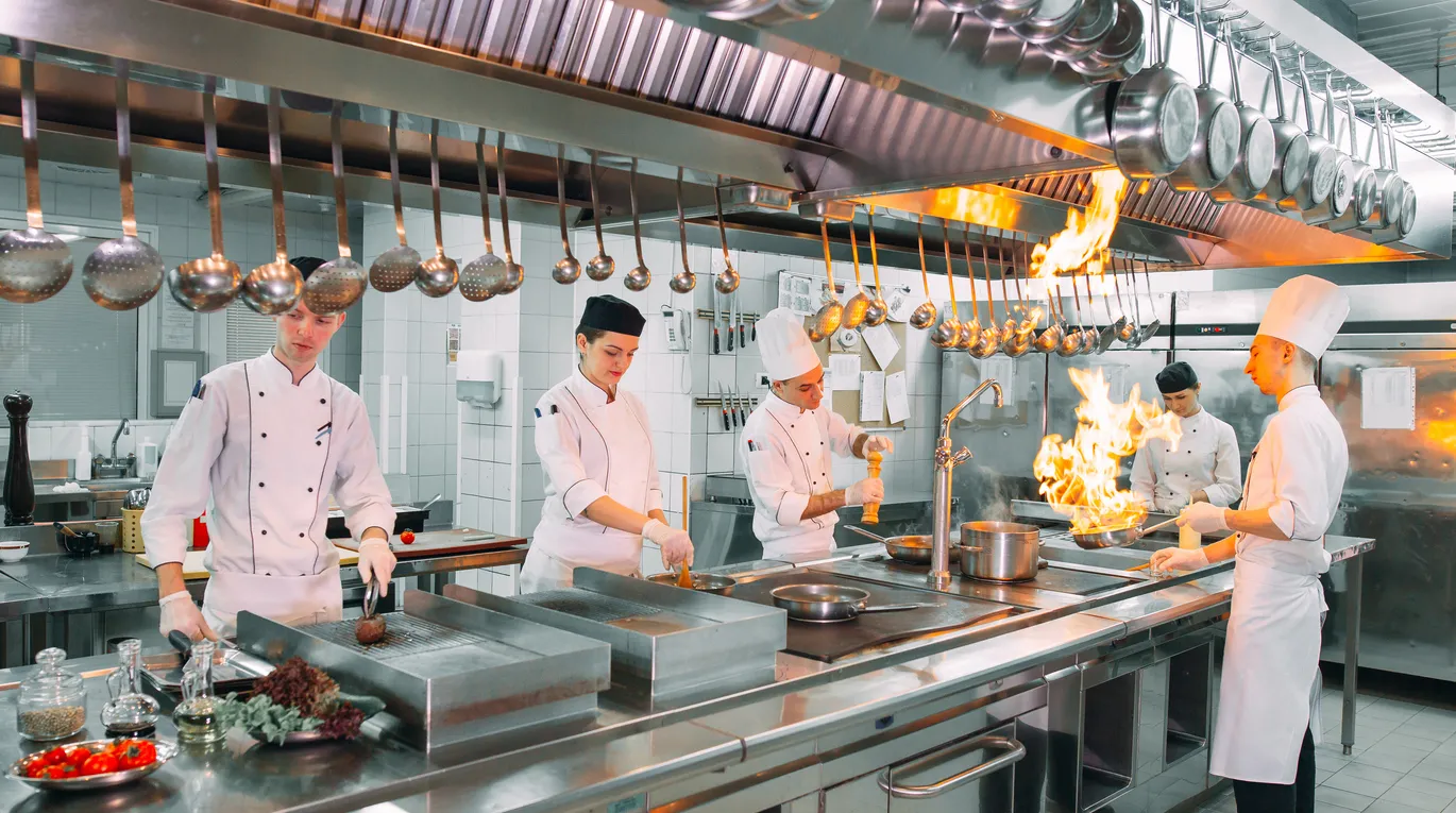 Cocina moderna. Los cocineros preparan comidas en la estufa de la cocina del restaurante o del hotel. El fuego en la cocina. 